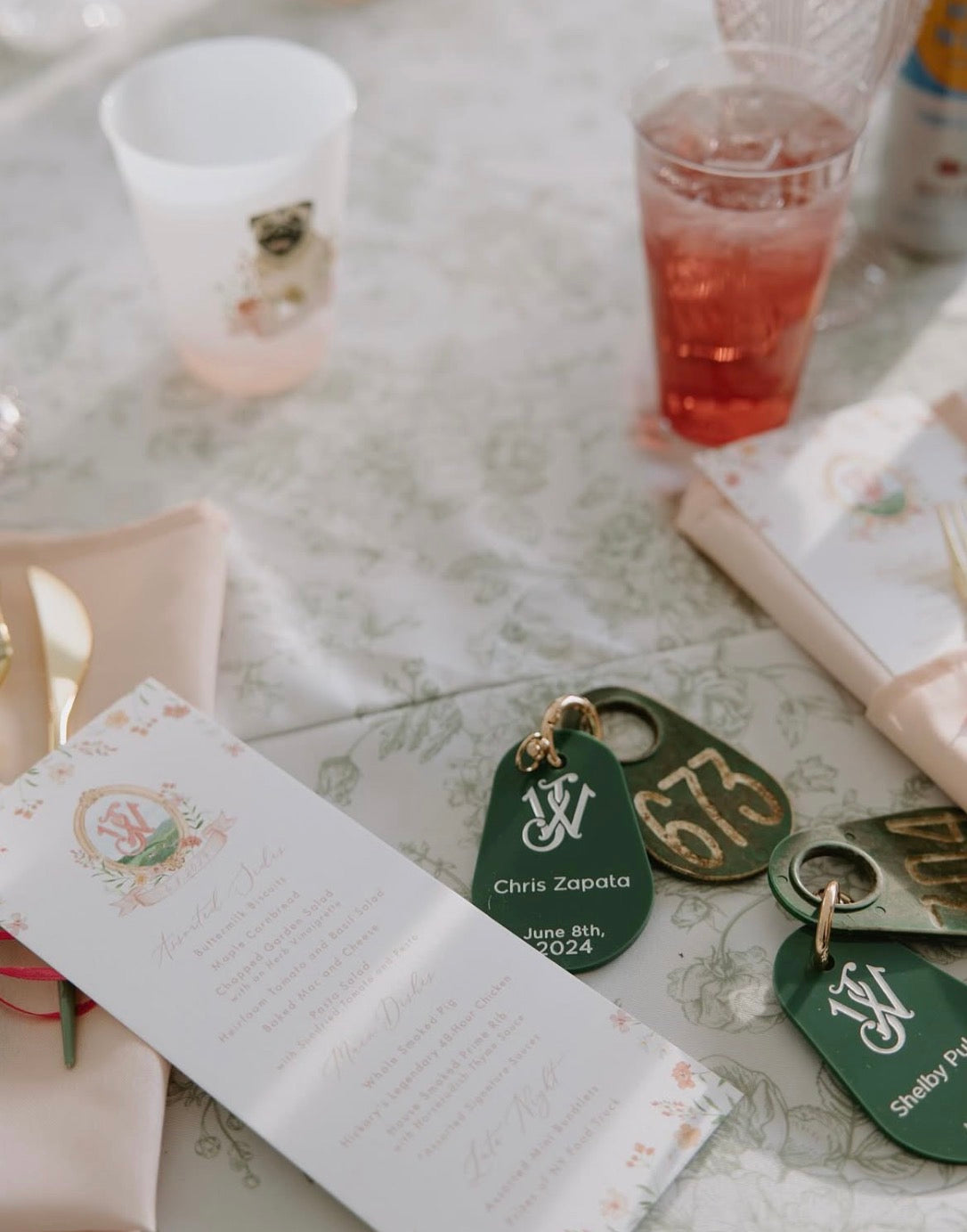 Table setting with name tags and a notebook on a floral tablecloth